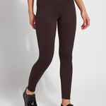 Person wearing brown leggings on a white background