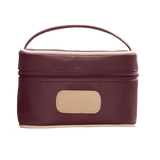 Burgundy cosmetic bag with beige handle and patch on a white background