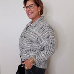 Woman wearing a patterned blouse against a plain background