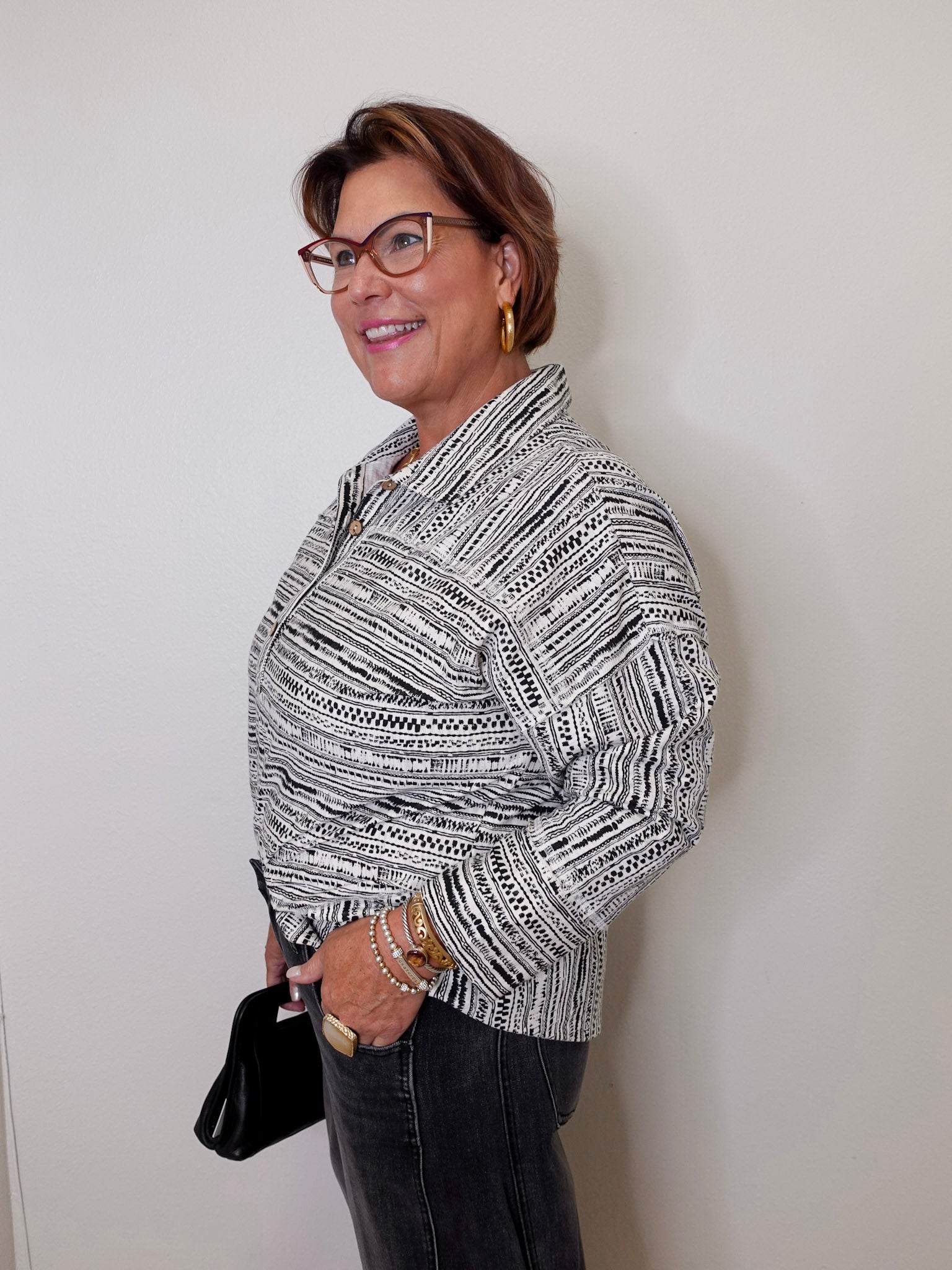 Woman wearing a patterned blouse against a plain background