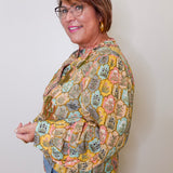 Woman wearing a patterned jacket against a plain background