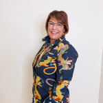 Woman wearing a colorful dragon patterned shawl against a white background