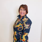 Woman wearing a colorful dragon patterned shawl against a white background