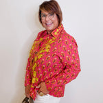 Woman wearing a pink floral top  against a white background