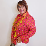 Woman wearing a pink floral top  against a white background
