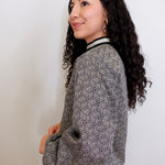 Woman wearing a patterned top against a plain background