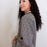 Woman wearing a patterned top against a plain background
