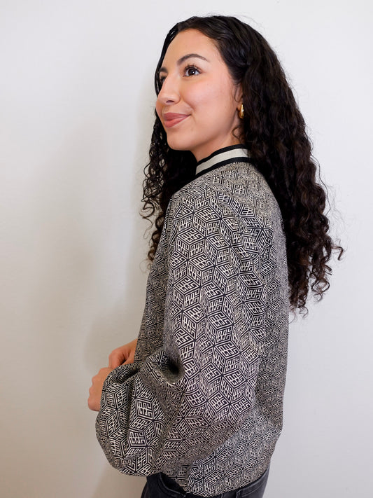 Woman wearing a patterned top against a plain background