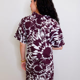 Woman wearing a patterned dress against a white wall