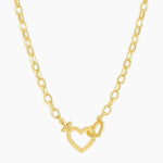 Gold necklace with a heart-shaped clasp on a white background