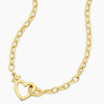 Gold chain necklace with a heart design on a white background