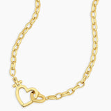 Gold chain necklace with a heart design on a white background