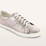 Silver sneaker with white laces on a light gray background