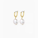 Gold hoop earrings with pearl drops on a white background