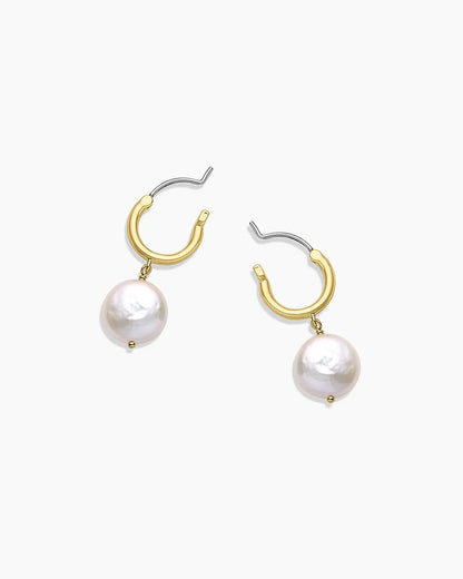 Gold hoop earrings with pearl drops on a white background