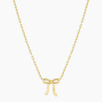 Gold bow-shaped pendant necklace on a white background