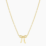 Gold bow-shaped pendant necklace on a white background