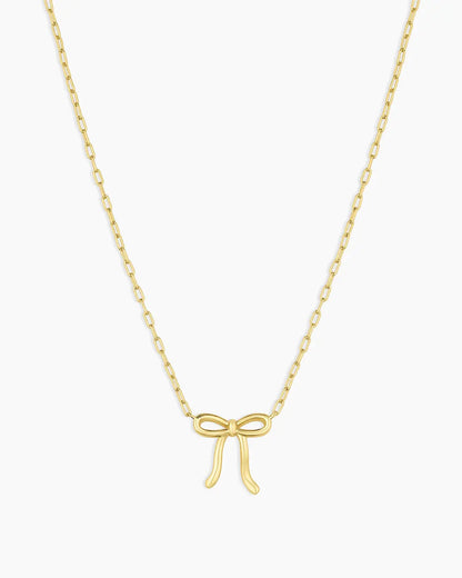 Gold bow-shaped pendant necklace on a white background