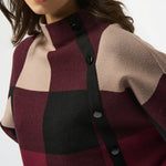 Close-up of a person wearing a checkered coat with a white background
