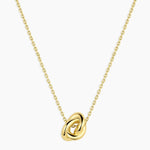 Gold necklace with a knot pendant on a white background