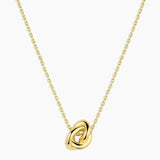 Gold necklace with a knot pendant on a white background
