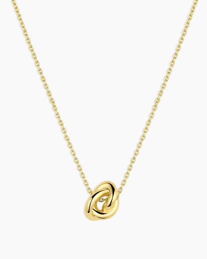 Gold necklace with a knot pendant on a white background