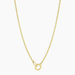 Gold necklace with a small round pendant on a white background