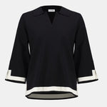 Black blouse with white trim on a white background