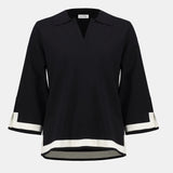 Black blouse with white trim on a white background