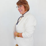 Woman wearing a white blazer and glasses against a white background