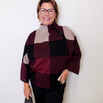 Woman wearing a checkered sweater with a neutral background