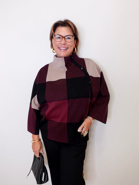 Woman wearing a checkered sweater with a neutral background