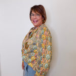 Woman wearing a colorful patterned shawl against a white background