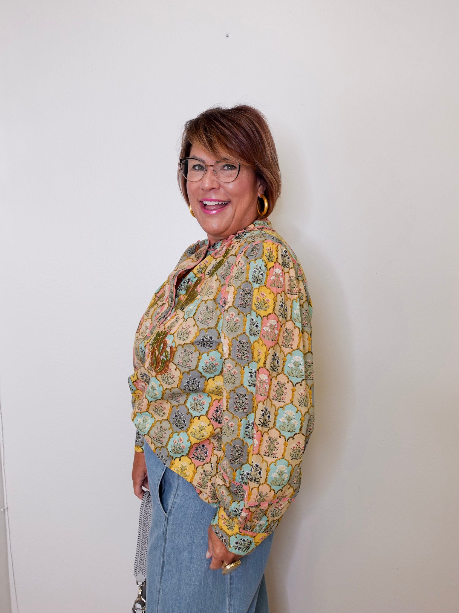 Woman wearing a colorful patterned shawl against a white background