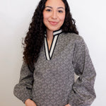 Woman wearing a patterned blouse with a white background