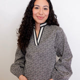 Woman wearing a patterned blouse with a white background