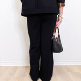 woman wearing a black pant against a white background 