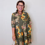 Woman wearing a patterned dress with a plain background
