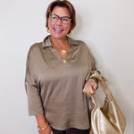 Woman holding a gold handbag against a white background