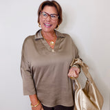 Woman holding a gold handbag against a white background