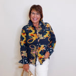 Woman wearing a colorful dragon-patterned jacket against a white background