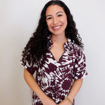 Woman wearing a patterned shirt against a plain background