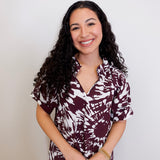 Woman wearing a patterned shirt against a plain background