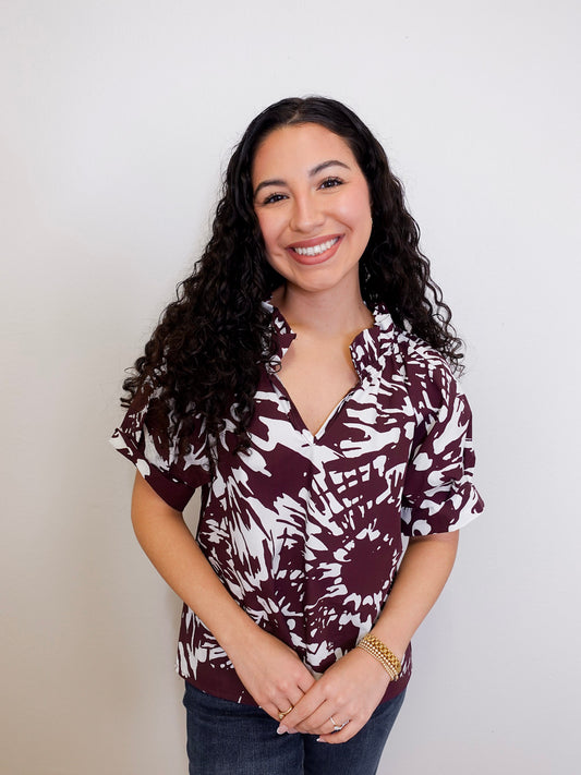 Woman wearing a patterned shirt against a plain background