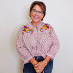 Woman wearing a floral blouse with a plain background