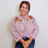 Woman wearing a floral blouse with a plain background