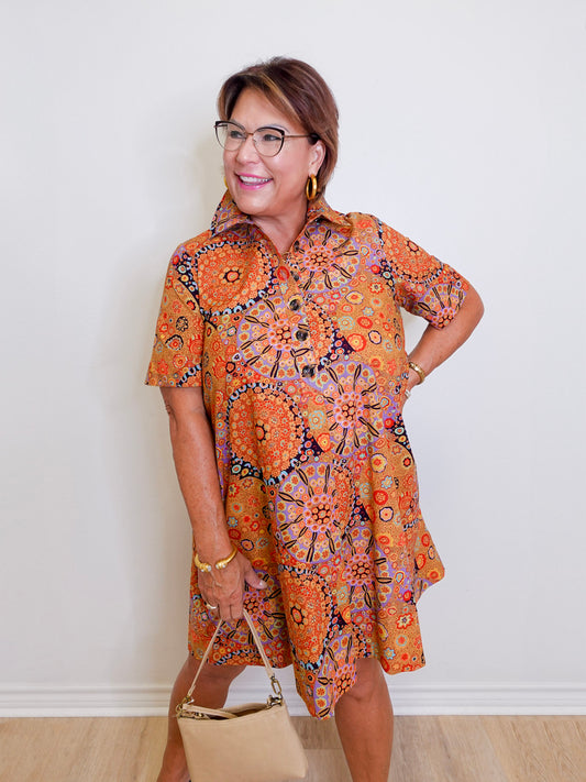 Woman wearing a patterned dress with a plain background
