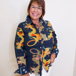 Woman wearing a colorful dragon patterned jacket against a white background