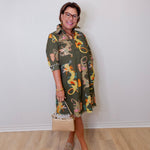 Woman wearing a patterned dress with a plain background