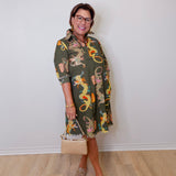Woman wearing a patterned dress with a plain background